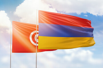 Sunny blue sky and flags of armenia and tunisia