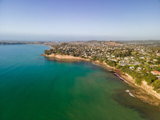 Fototapeta na wymiar Spectacular beachfront properties seen aerially from the sky by drone in Red beach, New Zealand 