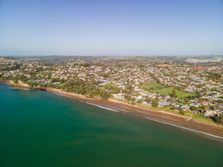 Fototapeta na wymiar Spectacular beachfront properties seen aerially from the sky by drone in Red beach, New Zealand 