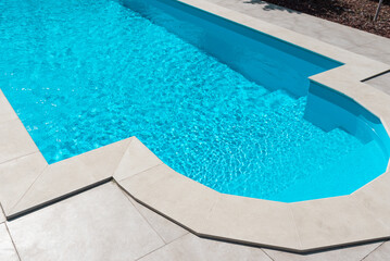 Clear blue water in the pool. Steps close-up. Relax in the backyard of a country house