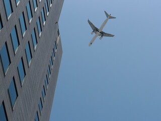 Fototapeta na wymiar ビルの上空を通過するジェット機