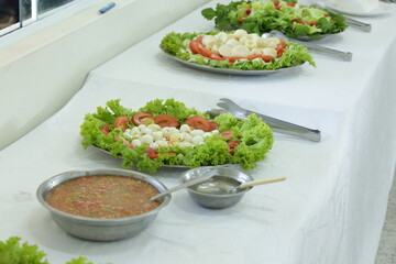 Prato com salada tomate e alface na mesa.