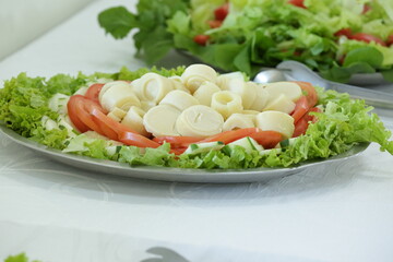 Prato com salada tomate e alface na mesa.