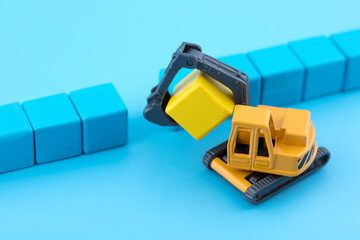 Miniature scene bulldozer digs away yellow blocks