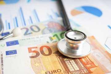 Stethoscope and Euro banknotes on chart or graph paper, Financial, account, statistics and business data  medical health concept.