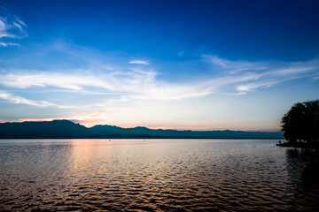 View of the lake and mountains during sunset at Kwan Phayao