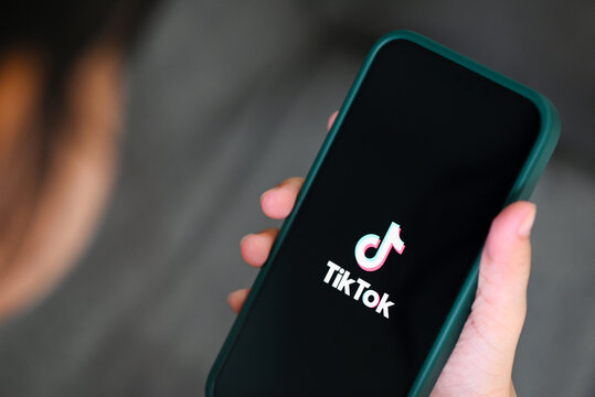 Child holding smartphone with TikTok application icon on Apple iPhone 13 Pro, Tiktok logo icon on the screen popular social media network from china, : Bangkok, Thailand - June 3 2022