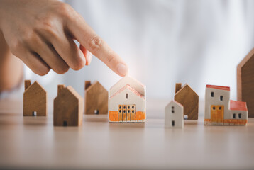 closeup woman finger pointing on beautiful home model