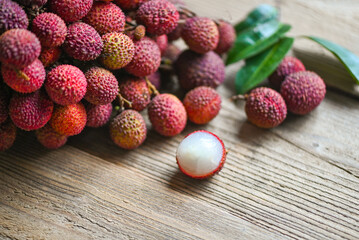 Lychee fruit on wooden background with green leaf , fresh ripe lychee peeled from lychee tree at tropical fruit Thailand in summer