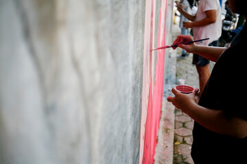 Artist hand drawing paint on the wall