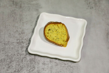 A piece of poppy seed cake served on a white plate.