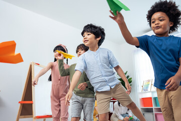 Group of Mixed race young little kid playing airplane in schoolroom. 