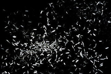 Heap of raw rice on dark background. Raw white rice explosion. faling rice on black background