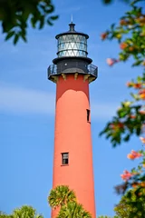 Foto auf Acrylglas Historic red brick Jupiter lighthouse against blue skies at Jupiter Inlet, Florida © Ryan Tishken