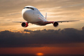 Fototapeta premium Passenger plane in flight. Front view of aircraft. Sunset time.