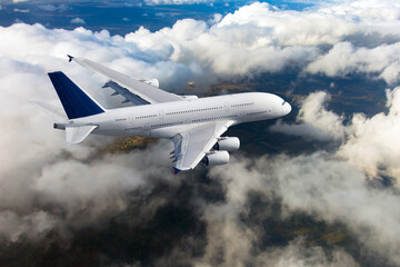 White passenger double decker plane in flight. Aircraft fly high above the clouds.