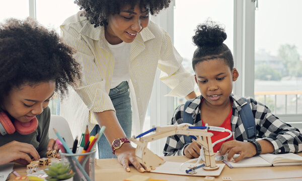 Classroom with diverse learners of happily African American students and teacher doing activities together. The teacher is teaching, guiding and talking to the children in diverse.