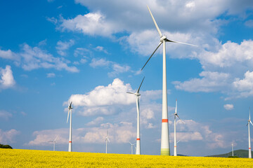 Wind turbines in a blooming rape seed field seen in Germany