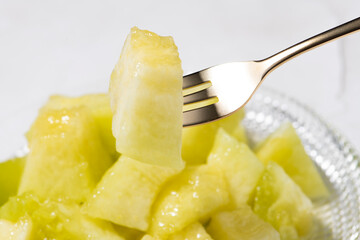 カットしたアールスメロンをフォークで食べる