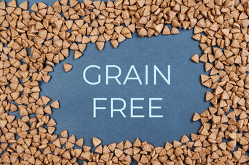 Dry cat food against a gray background. Pellets are triangular. Grain-free food for cats. Above...