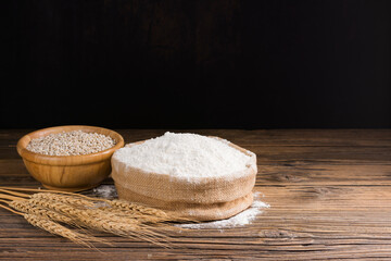 Organic Natural Whole Grain Flour in Sacks and wheat seeds Ears of wheat on an old wooden floor