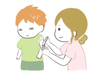 注射を我慢する男の子と看護師さん