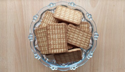 Digestive wheat glucose biscuit in isolated glass bowl plate with wooden table background surface....