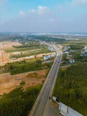 Fototapeta na wymiar Aerial view of National Route 14 in Binh Phuoc province, Vietnam with hilly landscape and sparse population around the roads