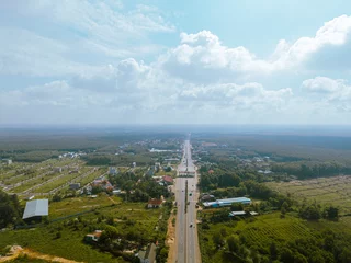 Fotobehang Aerial view of National Route 14 in Binh Phuoc province, Vietnam with hilly landscape and sparse population around the roads © CravenA