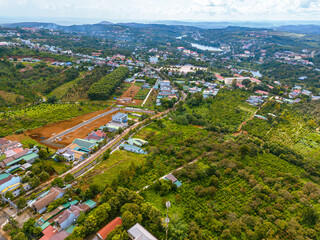 Aerial view of National Route 14 in Kien Duc town, Dac Nong province, Vietnam with hilly landscape and sparse population around the roads.