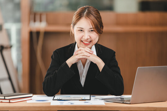 Portrait of an Asian woman working on a tablet computer in a modern office. Make an account analysis report. real estate investment information financial and tax system concepts