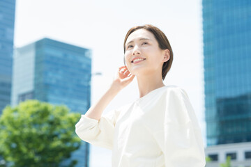 オフィス街に立つ笑顔の女性