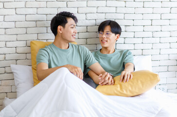 Two Asian cheerful lovely pride male gay men lover couple partner smiling laying down cuddling...