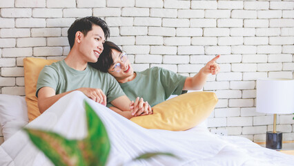 Two Asian cheerful lovely pride male gay men lover couple partner smiling laying down cuddling...