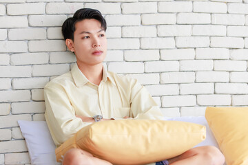 Closeup shot Asian young upset unhappy thoughtful teenager gay man boyfriend sitting alone on bed...