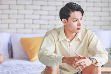 Closeup shot Asian young upset unhappy thoughtful teenager gay man boyfriend sitting alone on bed...