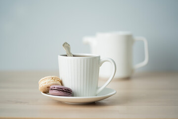 Tea time. Cup of tea with a teapot and macaroon.