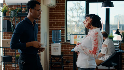 Hungry creepy zombie talking with businessman while dead coworker covered in blood walks by. Person...