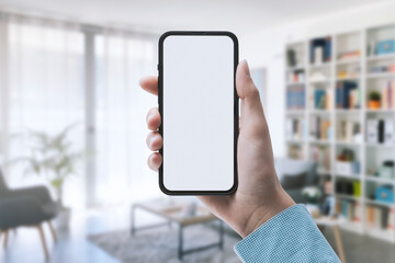 Woman holding a smartphone and room interior