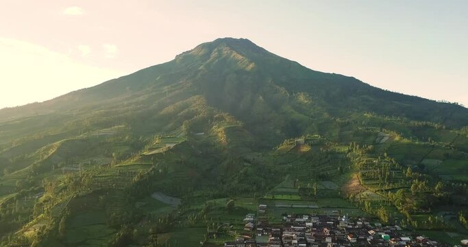 aerial shots from wonosobo region  indonesia of mount sumbing and the plantations on the mountain slopes and a village at the foot