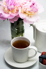 Fototapeta na wymiar Сup of tea, peony and berries.