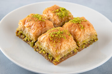  Pistachio baklava on a white plate.Traditional Turkish baklava on a white background
