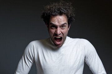 A young guy in agony, shouting and breaking into pieces