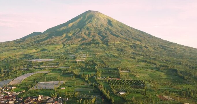aerial view of the countryside and plantations in the wonosobo region of indonesia mountain sindoro in the background in the sun