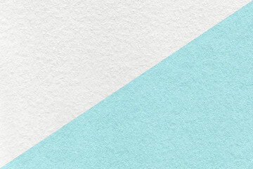 Fototapeta premium Texture of craft white and light blue paper background, half two colors, macro. Structure of turquoise kraft cardboard.