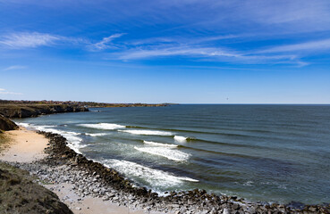 View of the city with buildings on a rocky shore near the Black Sea under sunset
