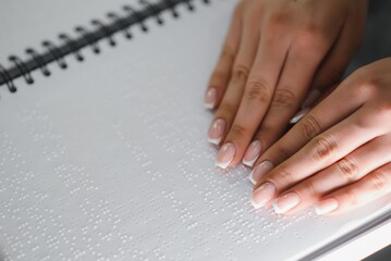 Blind woman read book written in Braille. Close up finger touch to braille Code