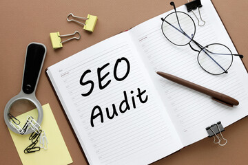SEO AUDIT. Business concept. open notepad. text on white paper. brown background
