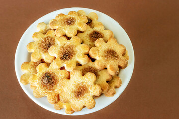 on a plate a bunch of cookies with cinnamon and sugar on a brown background