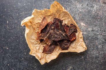 Beef jerky meat. Dried sliced meat on paper.